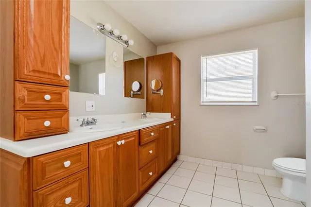 a bathroom with a granite countertop sink a mirror and a toilet