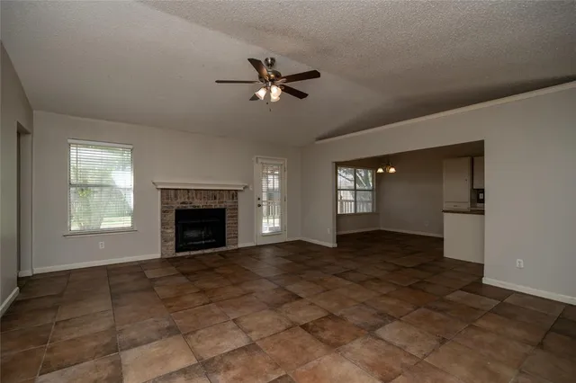 a view of an empty room with window and fire place