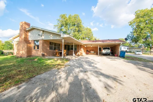 a view of a house with a yard and potted plants