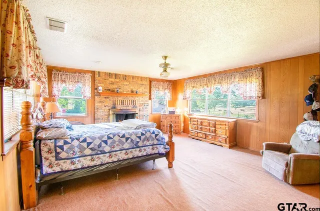 a bedroom with a bed and large windows