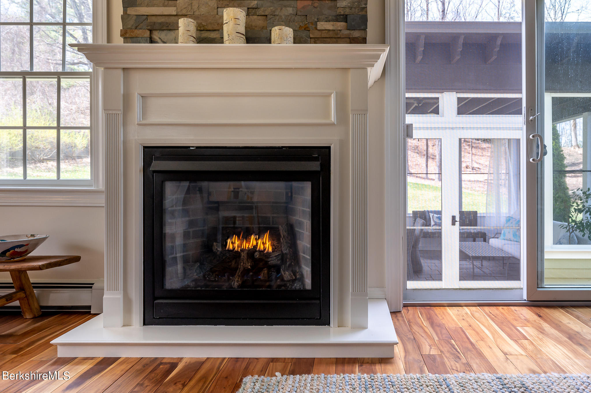 8 Castle Hill Road Stockbridge, MA 01262 - Photo 12 of 46 a living room with a fireplace a flat screen tv and a window