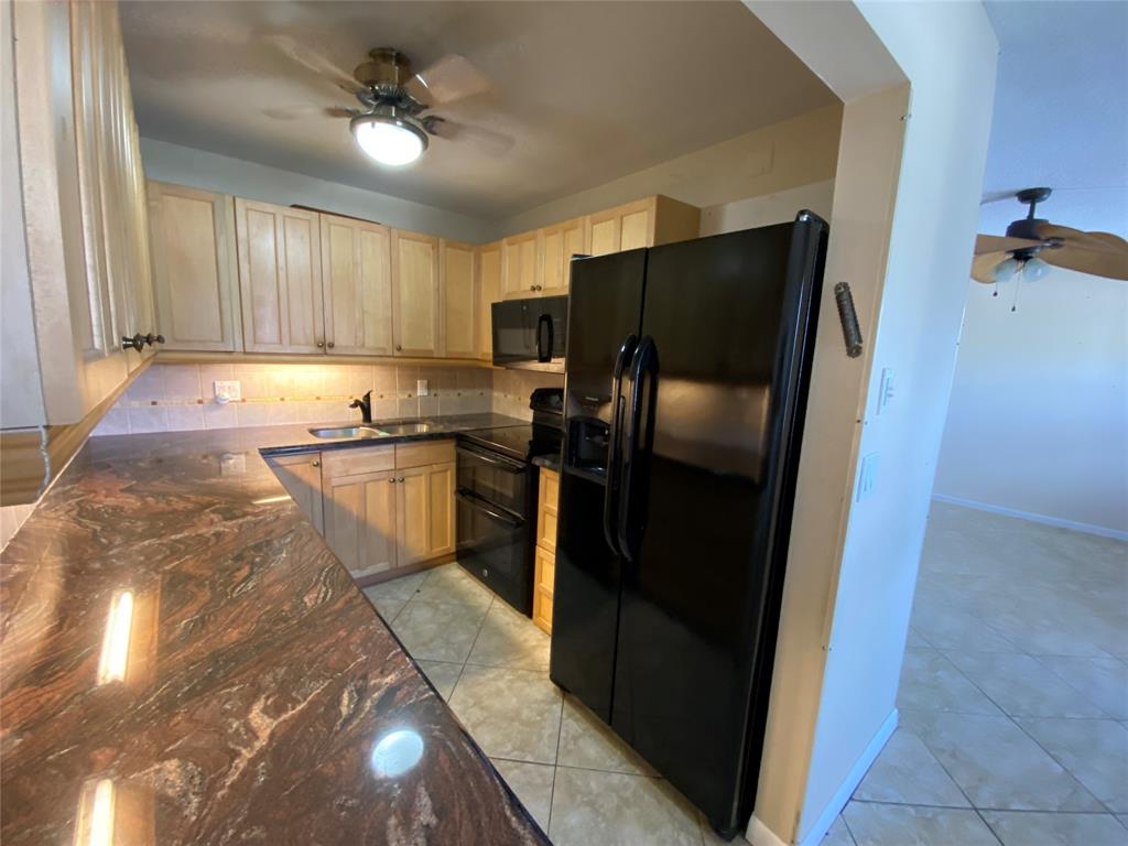 a kitchen with stainless steel appliances granite countertop a refrigerator a sink a stove and island