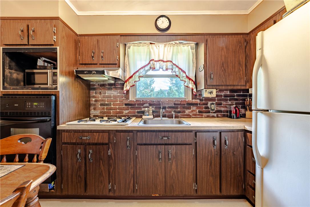 4352 Ruth Road Emmaus, PA 18049 - Photo 13 of 33 A well-appointed kitchen features ample wooden cabinetry and a classic brick-patterned backsplash.
