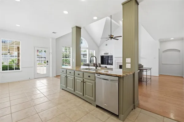 a bedroom with a bed next to a window with a chandelier