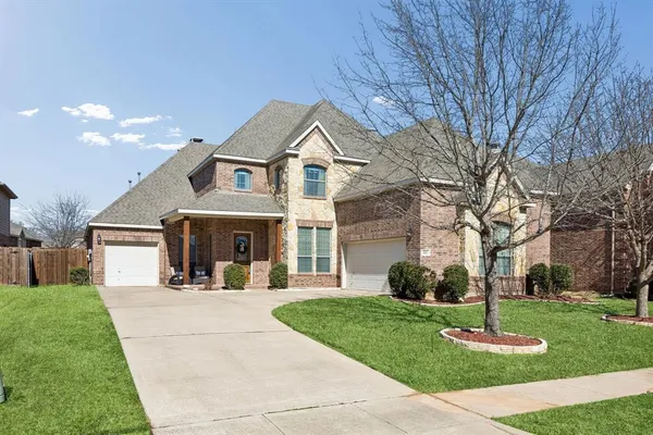 a front view of a house with a yard and trees