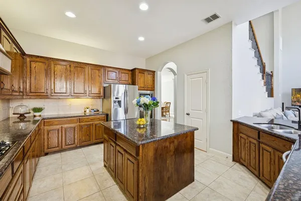 a kitchen with stainless steel appliances granite countertop a stove a sink dishwasher a refrigerator and a oven