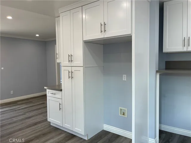 an empty room with wooden floor and cabinet