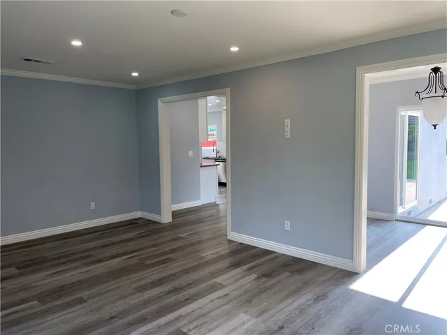 an empty room with wooden floor and entrance