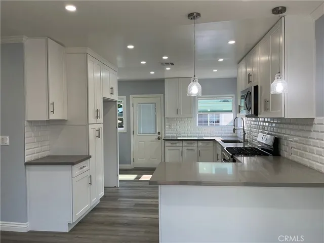 a large white kitchen with a large window
