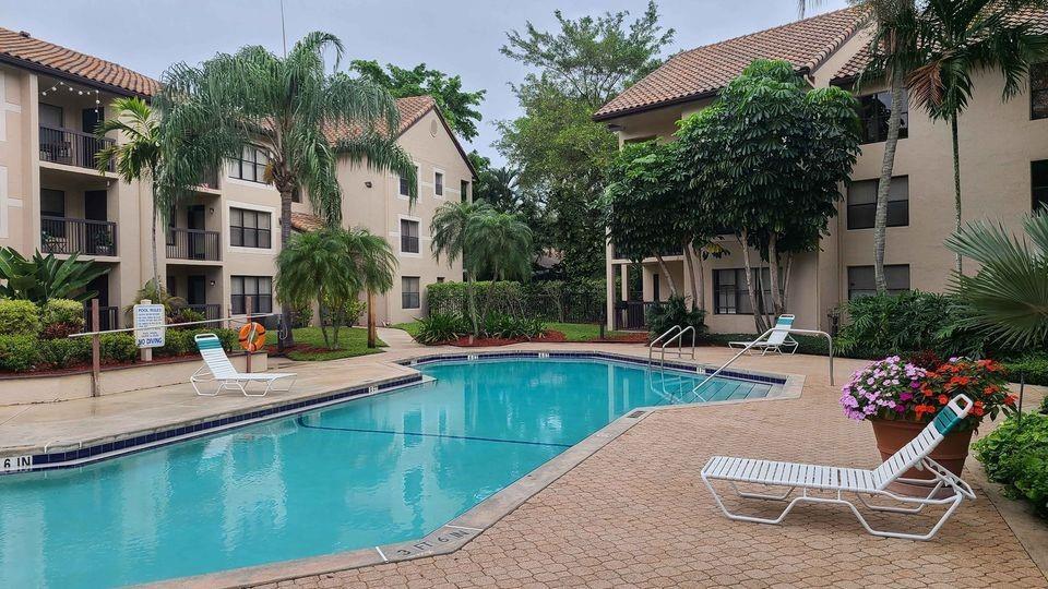 a view of a house with swimming pool and sitting area