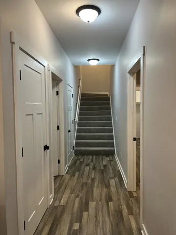 a view of a hallway with wooden floor and entryway