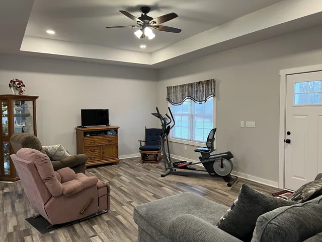 a living room with furniture and a flat screen tv with wooden floor