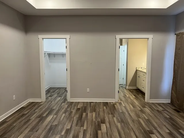 a view of a room with wooden floor and a bathroom