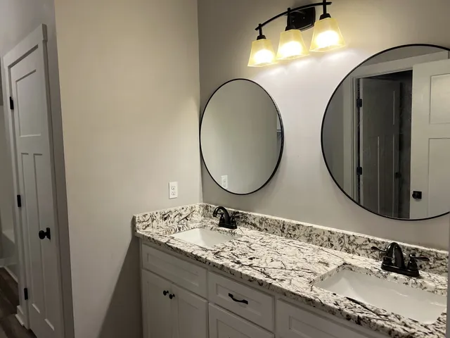 a bathroom with a double vanity sink and a mirror