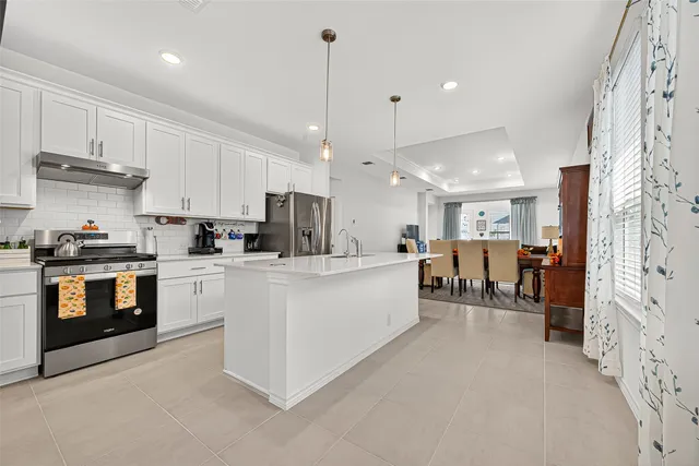 a large white kitchen with stainless steel appliances