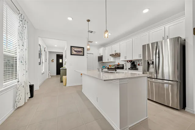 a kitchen with stainless steel appliances granite countertop a refrigerator a sink and a refrigerator