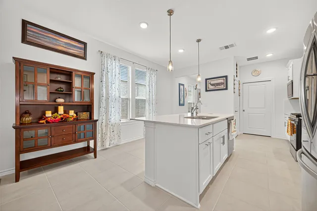 a kitchen with stainless steel appliances granite countertop a sink and a refrigerator