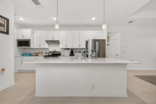 a kitchen with stainless steel appliances granite countertop a sink a stove and a refrigerator
