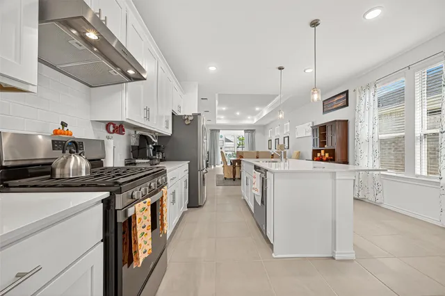 a kitchen with stainless steel appliances granite countertop a sink a stove and a refrigerator