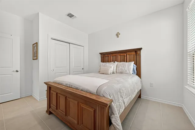 a bed sitting in a bedroom next to a bathroom