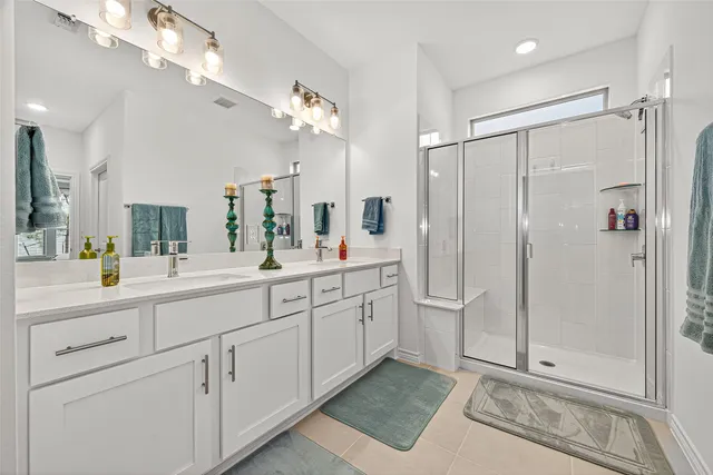 a spacious bathroom with a shower a sink and a mirror