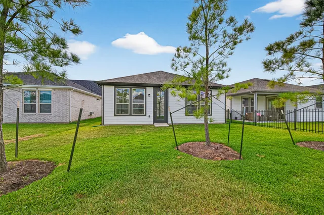 a view of a house with a yard and a large tree