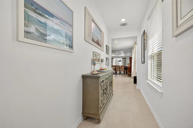 a view of a hallway with wooden floor and a kitchen