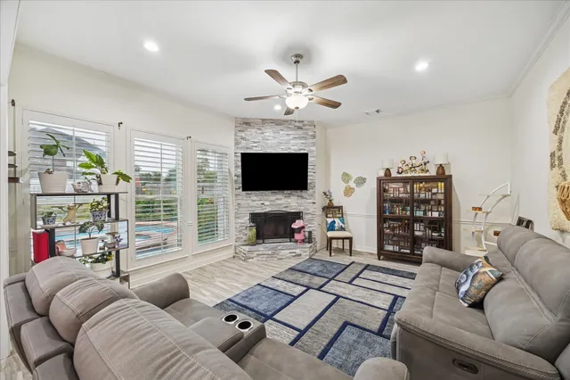 a living room with furniture a flat screen tv and a large window