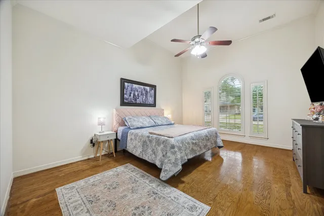 a bedroom with a bed window and a flat screen tv