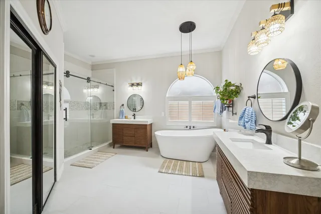 a spacious bathroom with a sink a mirror a bathtub and a shower