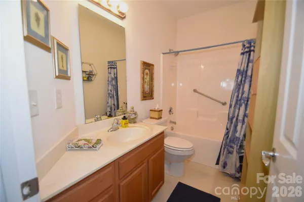 a bathroom with a sink a toilet a mirror and shower