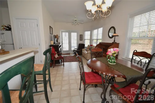a view of a dining room with furniture a chandelier and wooden floor