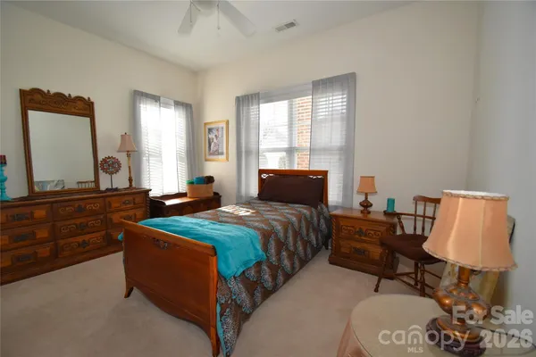 a bedroom with bed and window with chair
