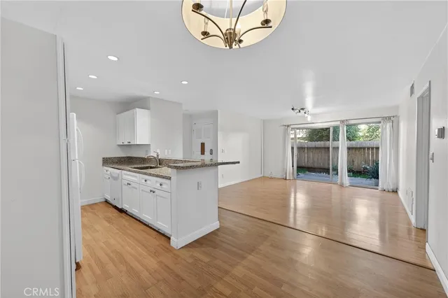 a kitchen with granite countertop a sink stove and refrigerator