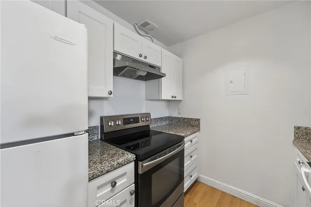 a bedroom with a large bed a chandelier and a dresser