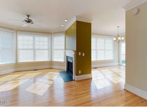 a view of an empty room with window and wooden floor