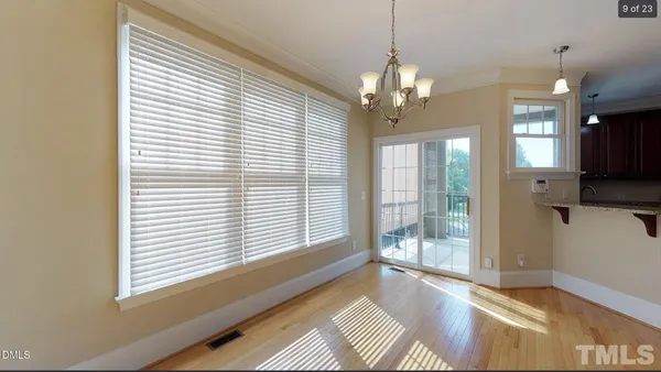 a view of a livingroom with a chandelier fan and windows