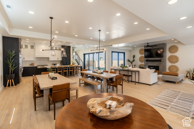 5355 Cyan Lane St. George, UT 84790 - Photo 6 of 6 Dining space featuring a raised ceiling, a fireplace, light wood-style floors, recessed lighting, and ceiling fan