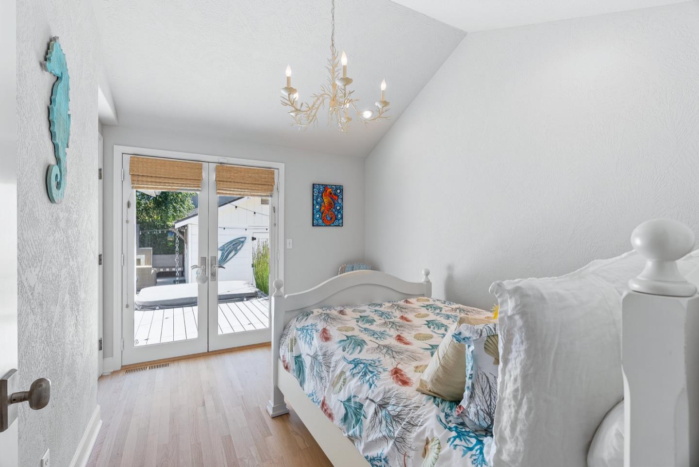 4940 Capitola Road Capitola, CA 95010 - Photo 10 of 25 a bedroom with a large bed and a chandelier next to a window