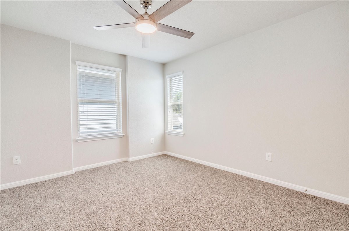 312 Triumph Road Buda, TX 78610 - Photo 26 of 36 an empty room with a window and a fan