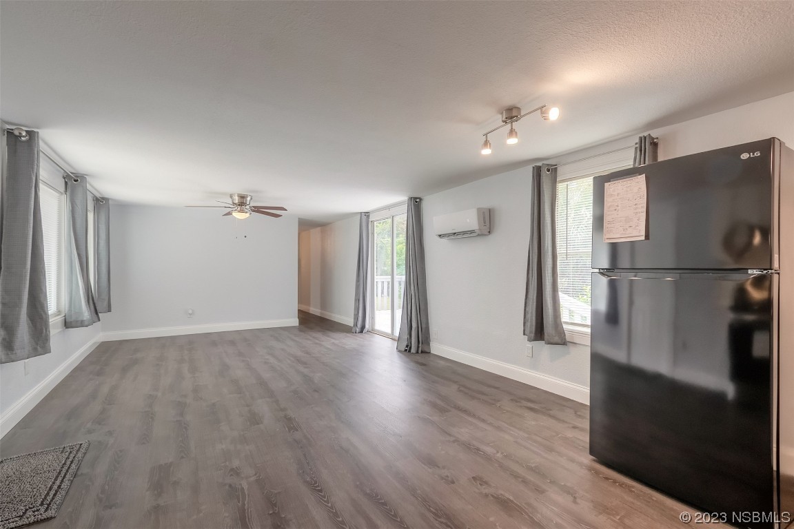 153 West Loop Oak Hill, FL 32759 - Photo 12 of 32 a view of an empty room with wooden floor and a window