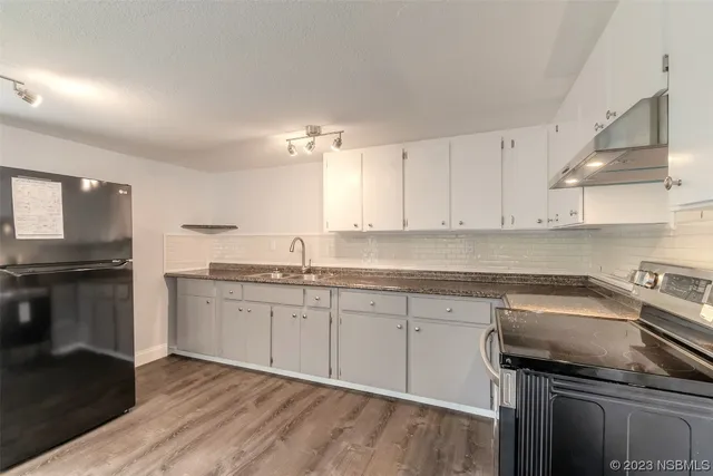 a kitchen with a sink stove and cabinets