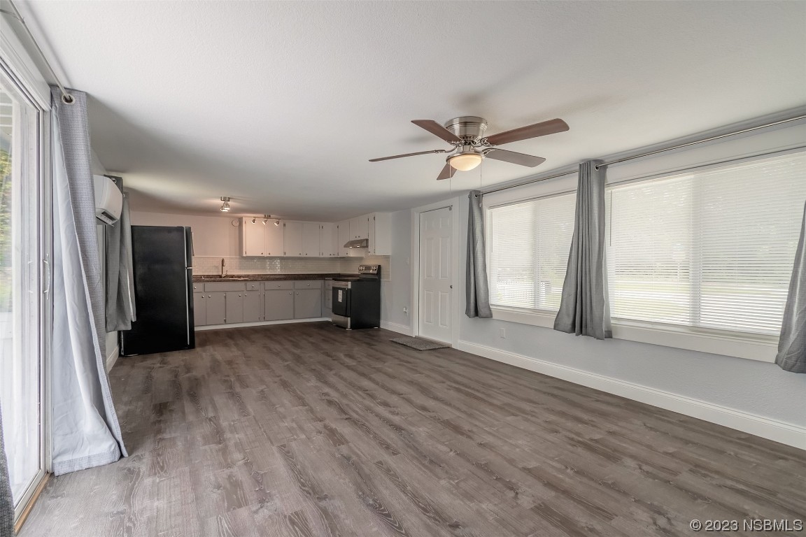 153 West Loop Oak Hill, FL 32759 - Photo 16 of 32 wooden floor in an empty room with a window