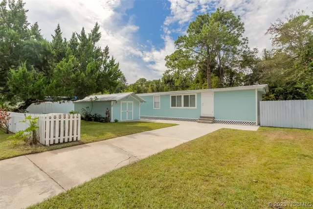 a view of a house with backyard and trees
