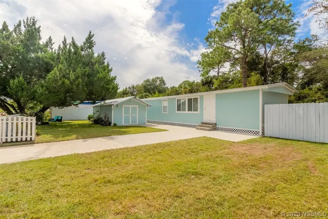 a view of an house with backyard and trees