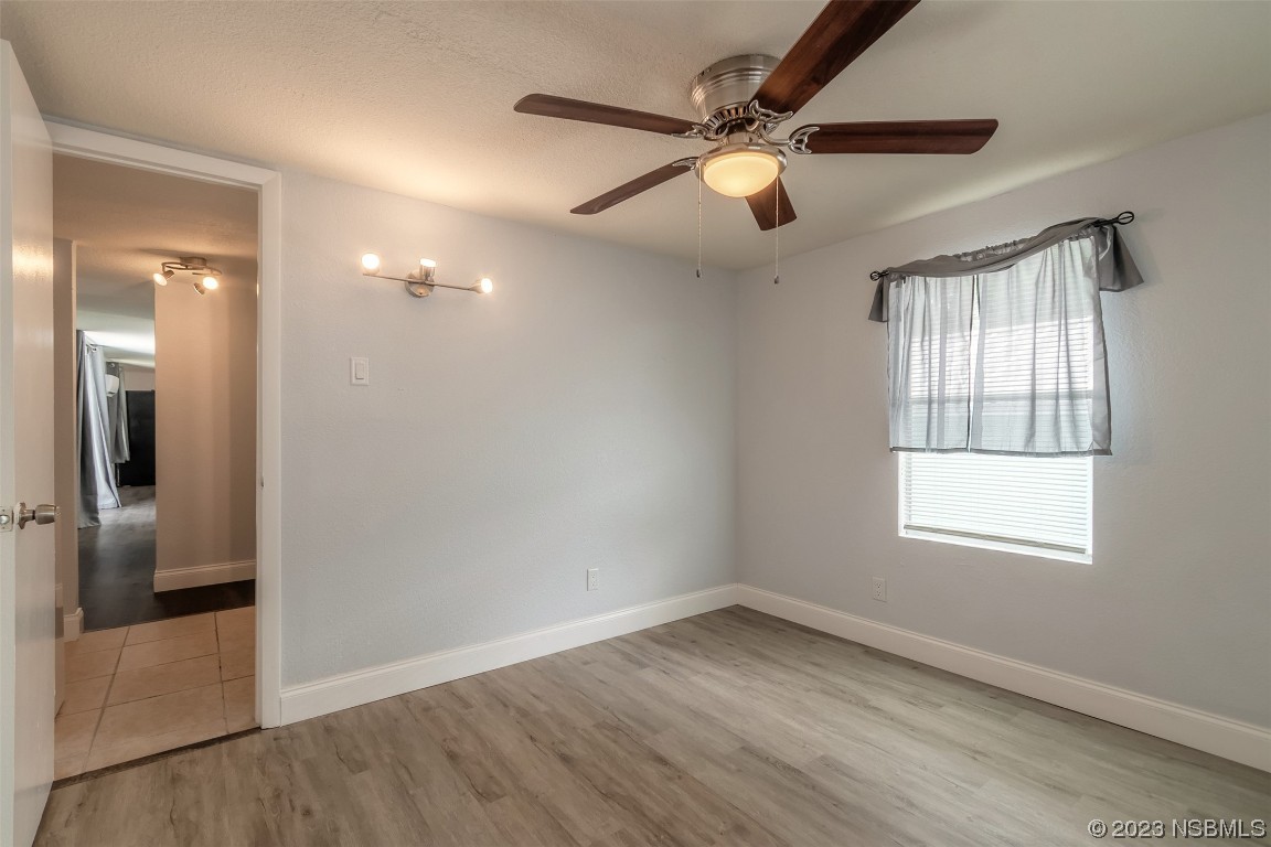 153 West Loop Oak Hill, FL 32759 - Photo 7 of 32 an empty room with wooden floor fan and windows