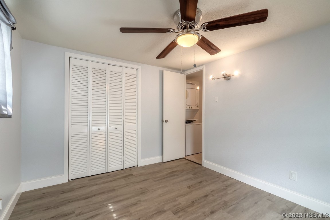 153 West Loop Oak Hill, FL 32759 - Photo 8 of 32 an empty room with wooden floor fan and windows