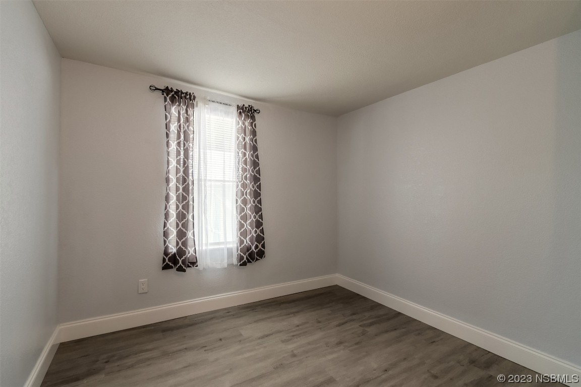 153 West Loop Oak Hill, FL 32759 - Photo 10 of 32 an empty room with wooden floor and windows