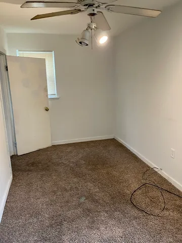 a view of an empty room with a fireplace and a window