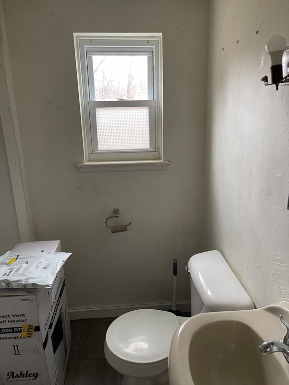 22 Commonwealth Avenue, Unit 1 North Attleboro, MA 02760 - Photo 5 of 6 a white toilet sitting next to a bathroom sink